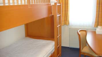 Una cama individual superpuesta con escritorio, silla, radiador y televisor.