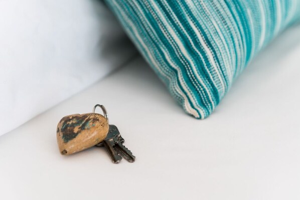 A heart-shaped keychain with keys and a fabric with teal and white stripes.