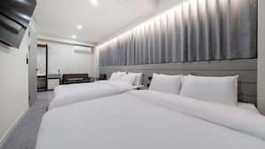Una habitación de hotel moderna con una cama grande, un escritorio y un televisor de pantalla plana.
