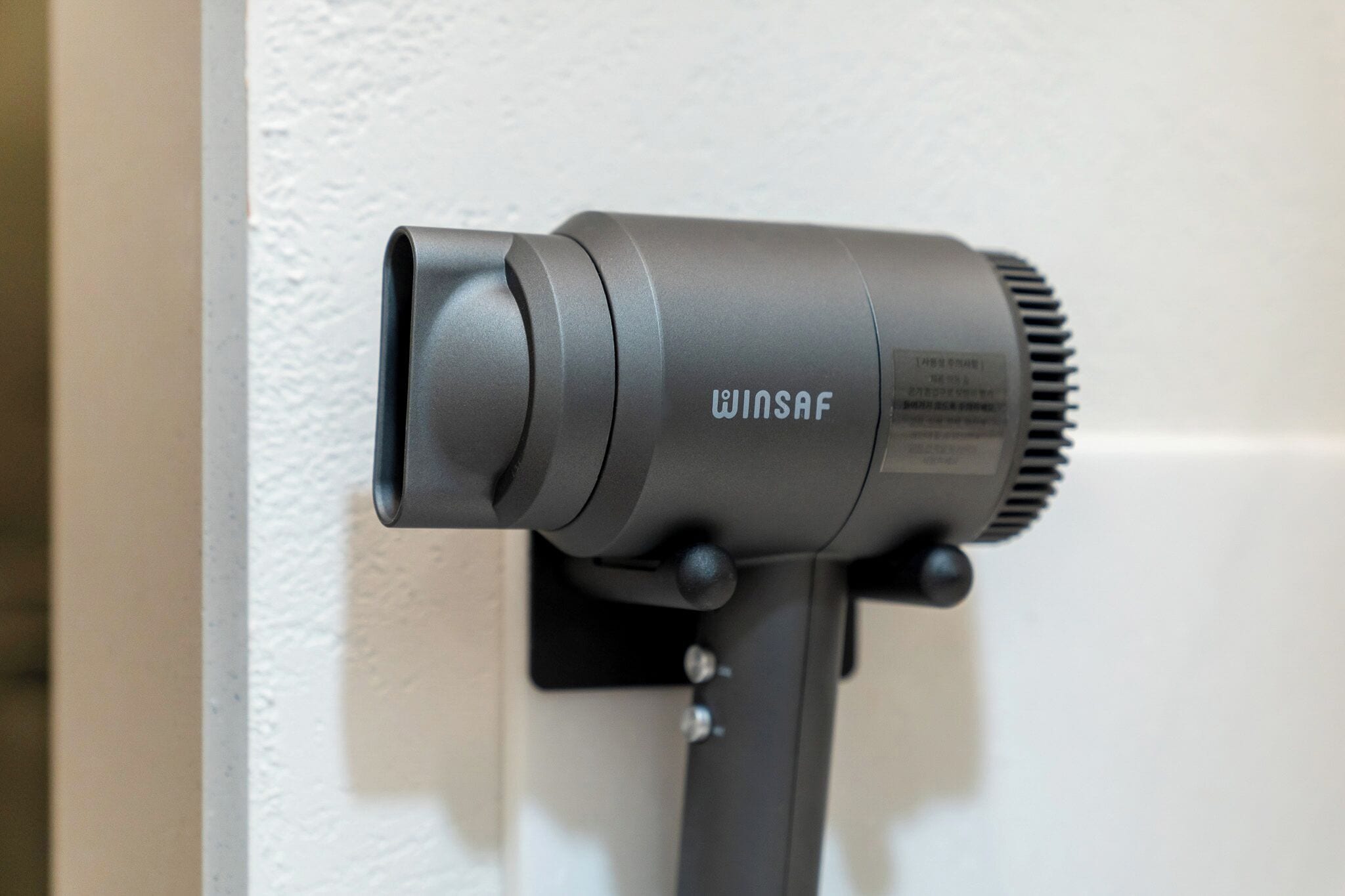 A Winsaf hair dryer mounted on a wall.