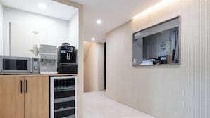 Una cocina moderna con microondas, cafetera y refrigerador.