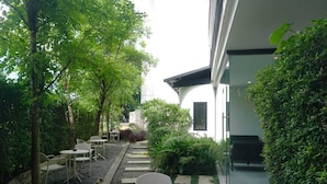 A modern outdoor patio with seating and a pathway leading to a building. - Collection O The Singha Chiangmai Hotel (Chiang Mai)