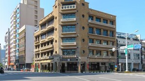 Un edificio de varios pisos con un atrio central, balcones y una entrada a nivel de calle.