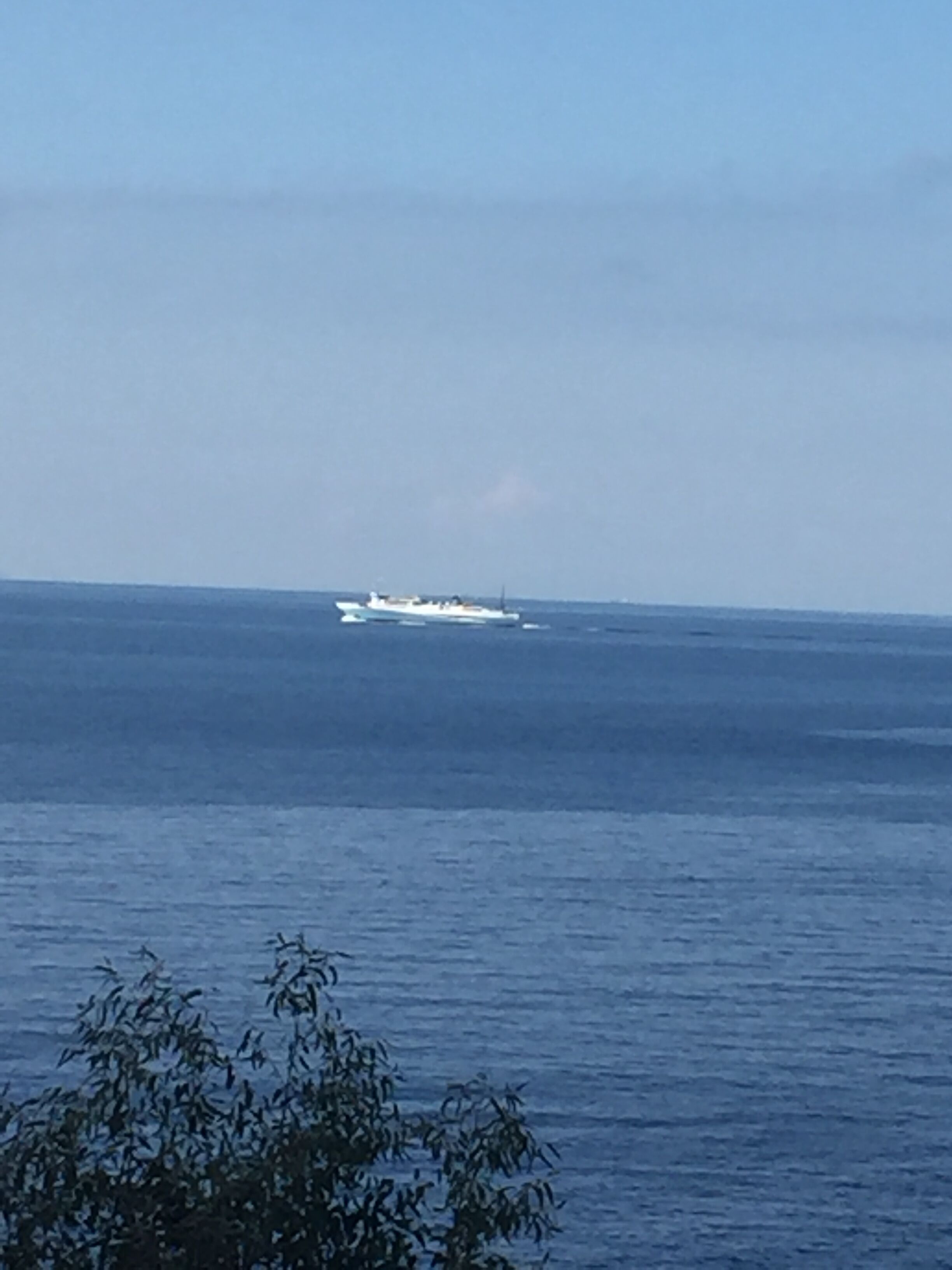 Une vue sur une étendue d’eau avec un navire à l’horizon.