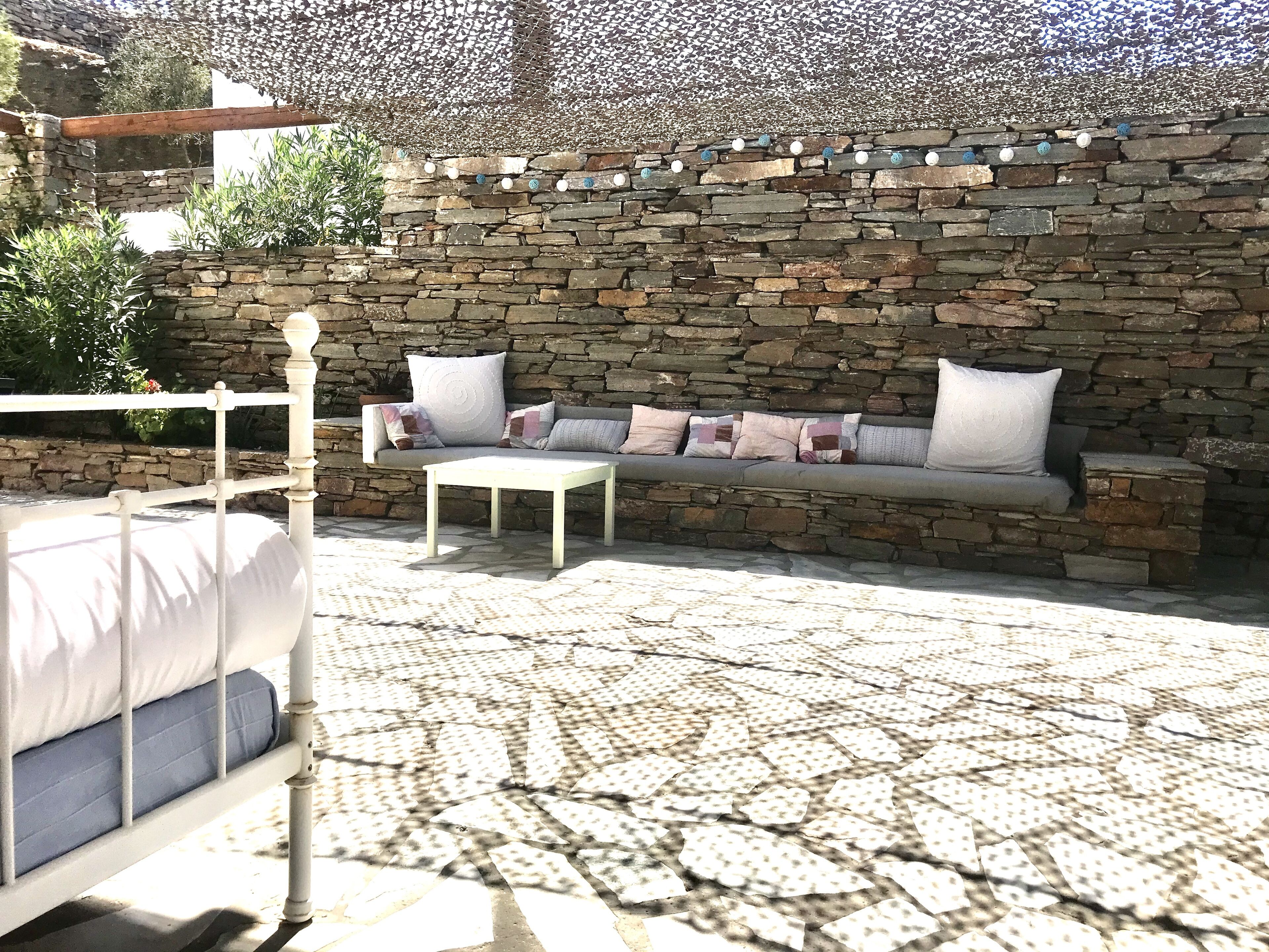 A stone wall with a stone bench and a white table.