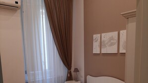 A hotel room with a bed, a bedside table, a lamp, and a wall-mounted air conditioner. - B&B La Baia Di Partenope (Naples)