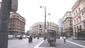 A city intersection with a bus stop, buildings, and vehicles. - B&B La Baia Di Partenope (Naples)