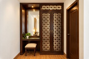 Una habitación con un armario de madera, un banco y un espejo.