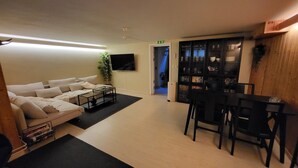 A living area with a sofa, a coffee table, and a bookshelf. - Hotell Zlafen B&B (Karlskoga)