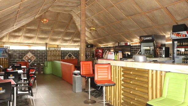 Un restaurant avec un plafond haut, des poutres en bois et un bar décoré aux couleurs de la marque Guinness.
