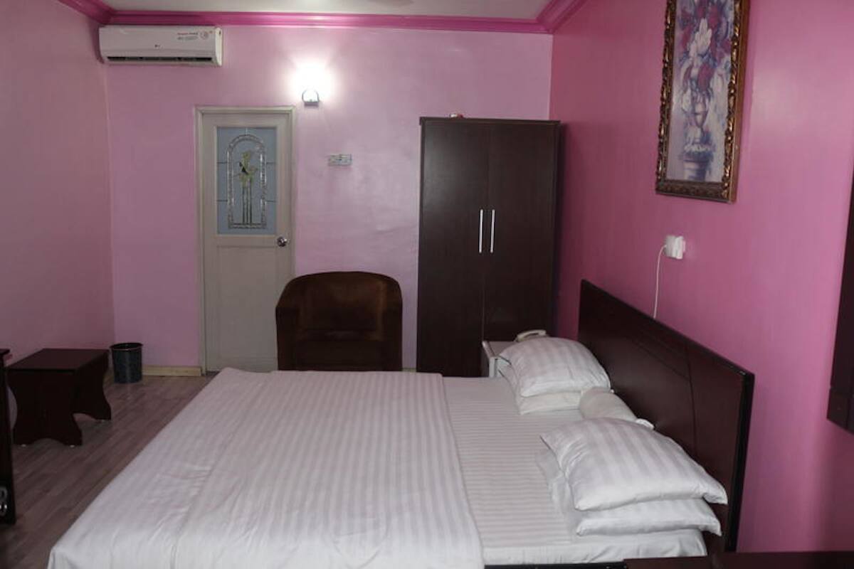 Un dormitorio con cama, armario, silla y puerta.