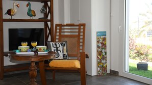 Un espace repas comprenant une table en bois, des chaises et un téléviseur.