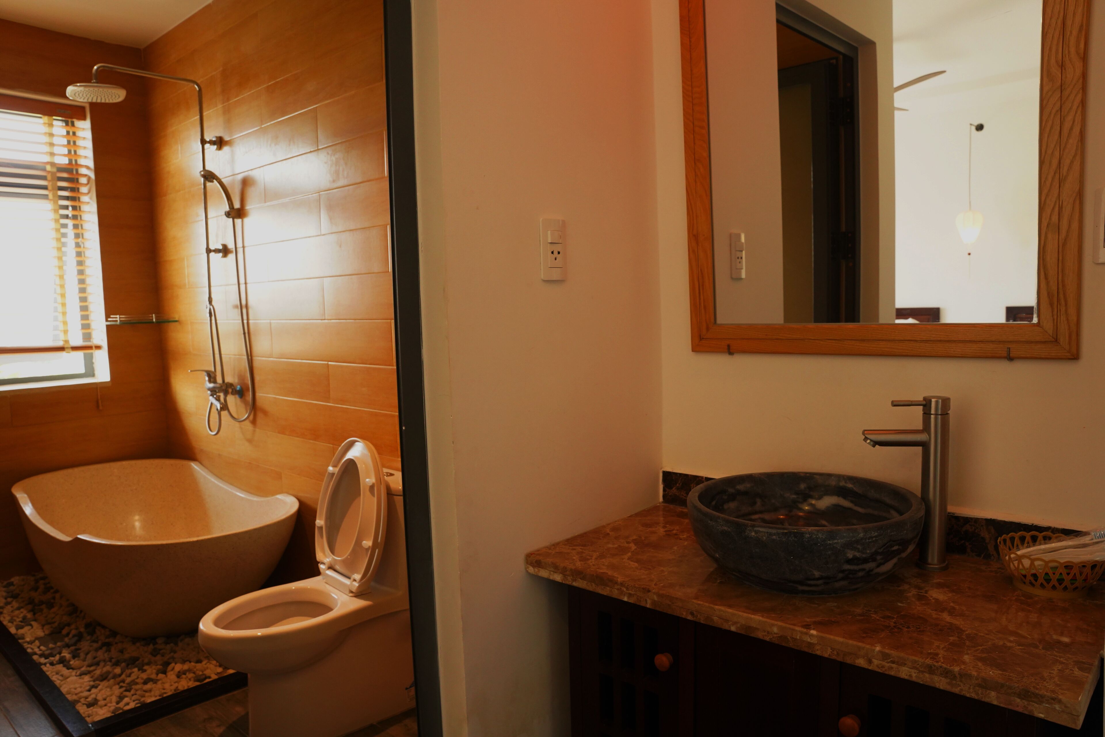 A bathroom with a freestanding bathtub, a toilet, a sink with a bowl, and a mirror.