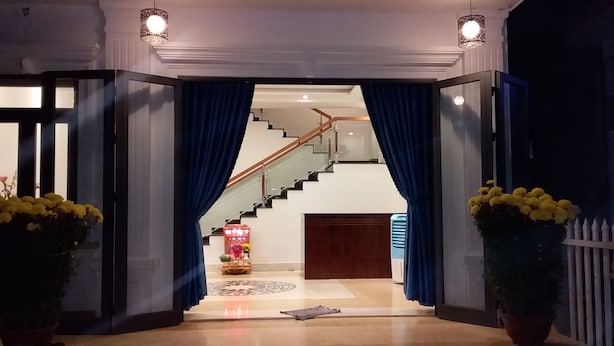 A grand entrance with a staircase leading to an upper level. - Hoang Y Homestay (Da Nang)