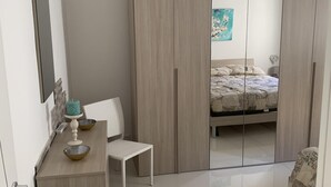 A bedroom with a bed, a wardrobe, a desk, and a chair. - Holiday House Partanna Mondello (Mondello)