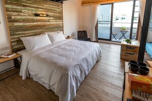 A bedroom with a large bed, a wooden headboard, a small table with a plant, and a view of the outside through a large window. - Atreeium (Tainan)