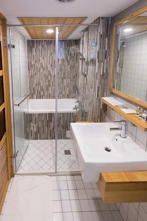 A modern bathroom with a glass-enclosed shower, a white bathtub, and a large mirror above the sink. - Atreeium (Tainan)