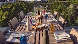 Een gedekte tafel voor het diner met uitzicht op de stad, inclusief gebouwen en bomen.