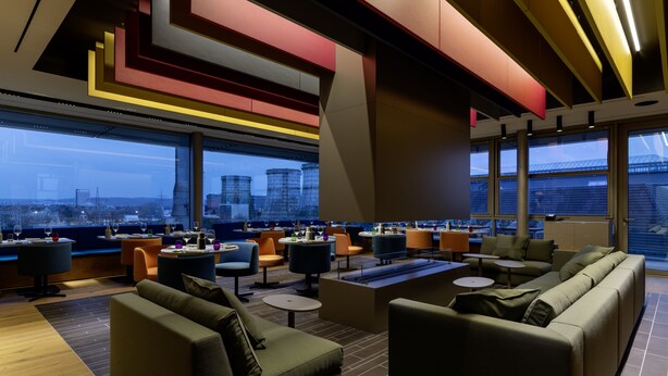 Un salon moderne avec des canapés, des tables et une vue sur la ville.