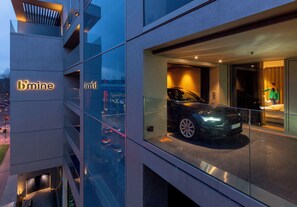 A modern building with a glass facade, a car displayed in the window, and the sign 'b'mine'. - b'mine Duesseldorf, WorldHotels Crafted (Düsseldorf)