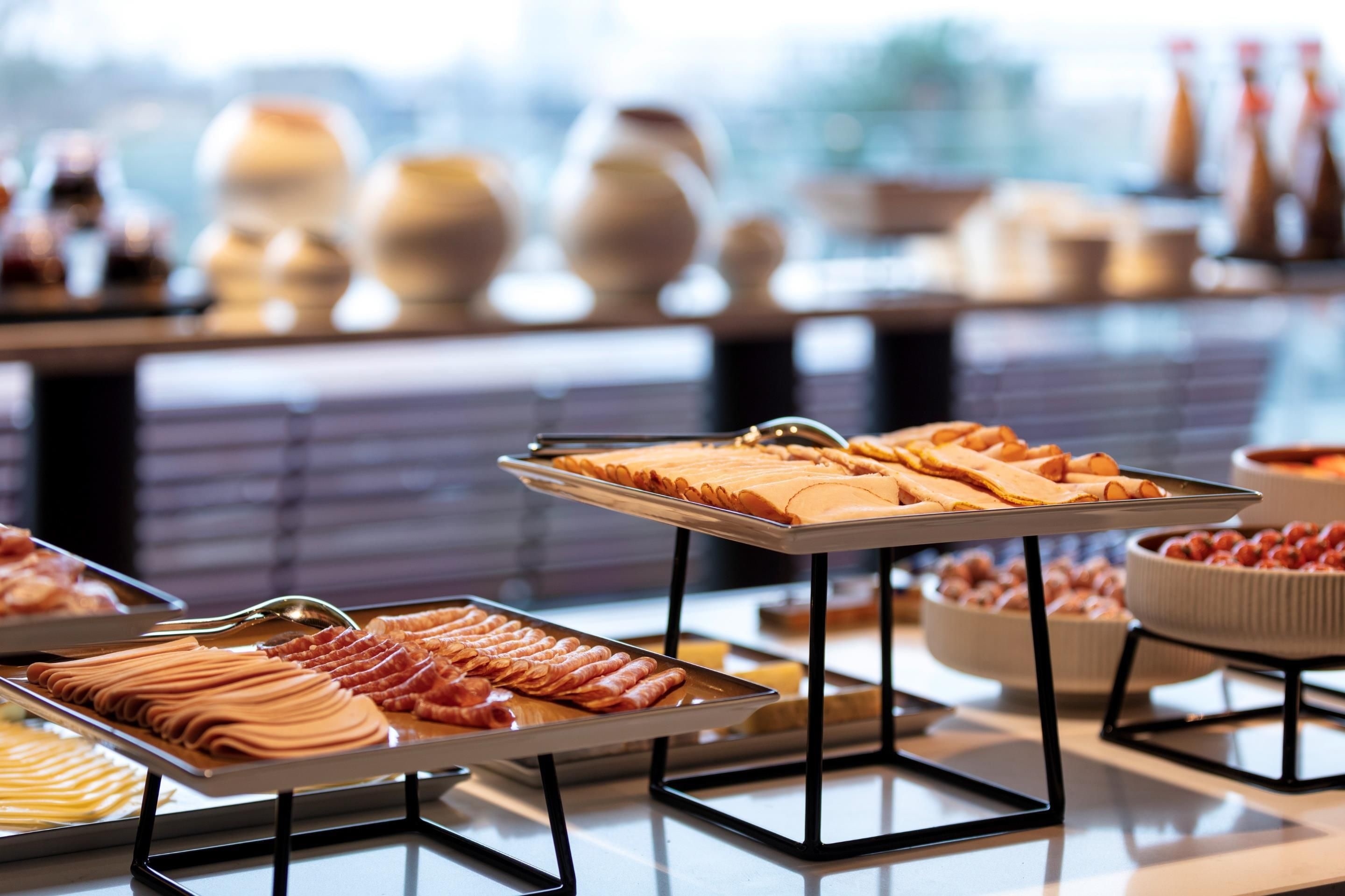 Un bufé con diversos alimentos y jarrones decorativos.