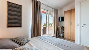 A bedroom with a bed, a desk, and a wardrobe.
