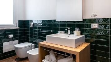 Ein modernes Badezimmer mit einem Holzlagerfläschchen, einem großen Spiegel und einer Toilette.
