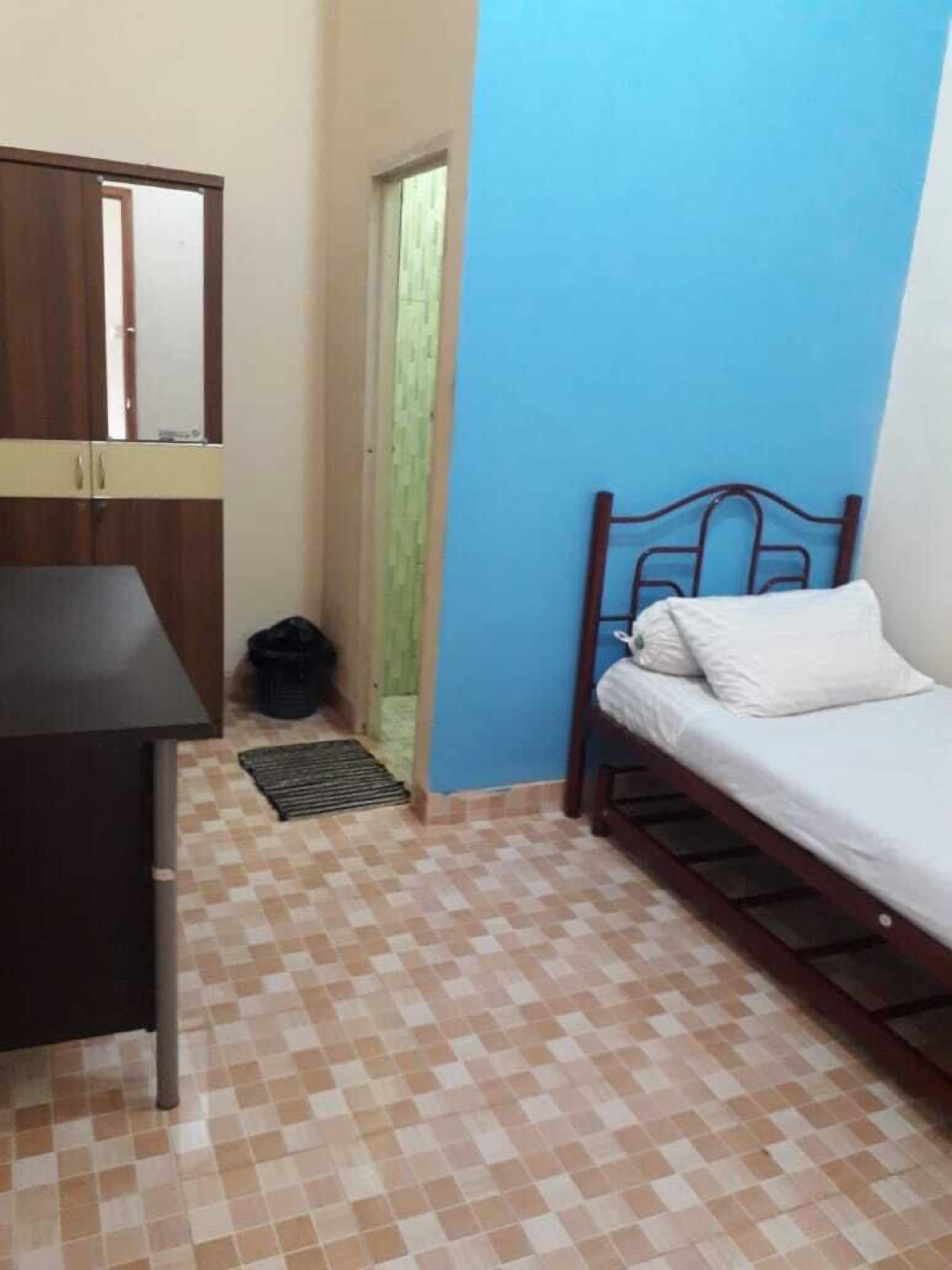 A small room with a bed, a desk, and a wardrobe.