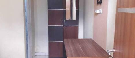 Un pasillo con un banco de madera, un armario y una puerta con cerradura.