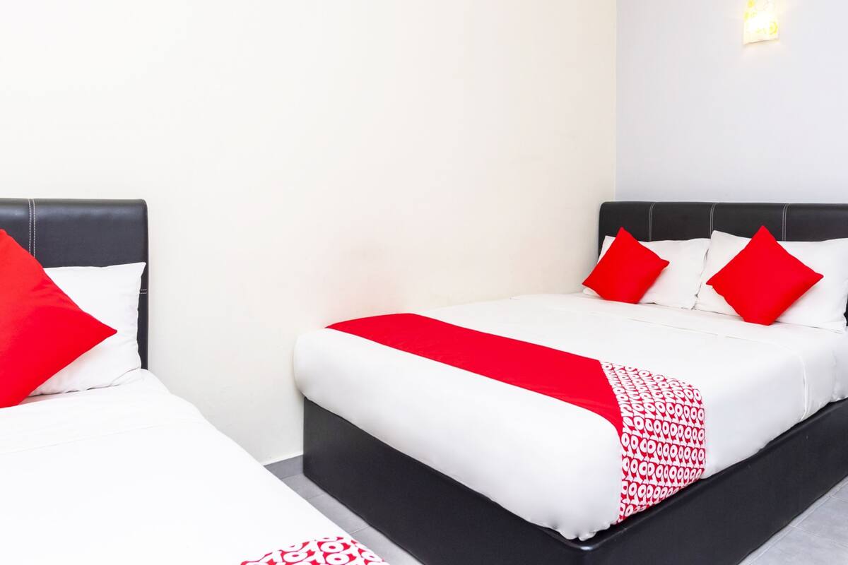 A hotel room with two beds, each with a black headboard and white bedding.