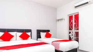Hotellihuone, jossa on kaksi sänkyä. Jokaisessa sängyssä on punavalkoiset vuodevaatteet, musta pääty ja punavalkoinen kuviollinen peitto.