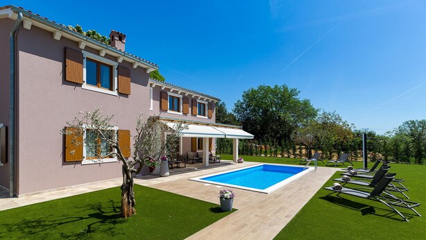 Une maison à deux étages dotée d’une piscine, d’un espace extérieur aménagé et d’une pelouse bien entretenue.