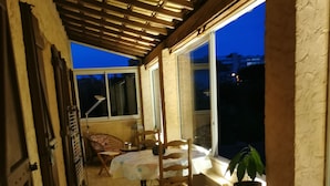 A covered patio area with a table and chairs, a potted plant, and a view of the outside. - Quiet home in the 2-star Mimosa City (Mandelieu-la-Napoule)