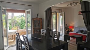 A spacious living area with a dining table, chairs, a sofa, and a fireplace. - Quiet home in the 2-star Mimosa City (Mandelieu-la-Napoule)