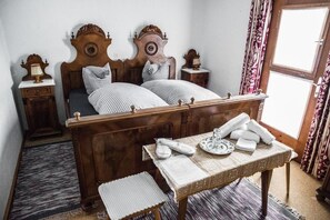 Classic bedroom with a four-poster bed, bedside tables, and a small table with amenities.