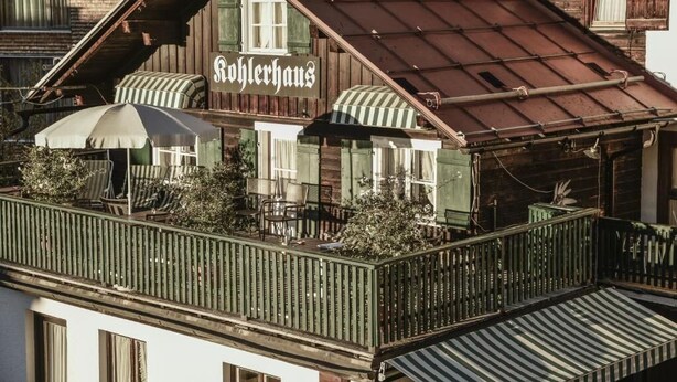 Un edificio de madera con balcón y un letrero que dice "Rohlerhaus".