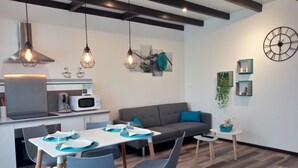 A modern kitchen with a microwave, stove, and hanging pendant lights.