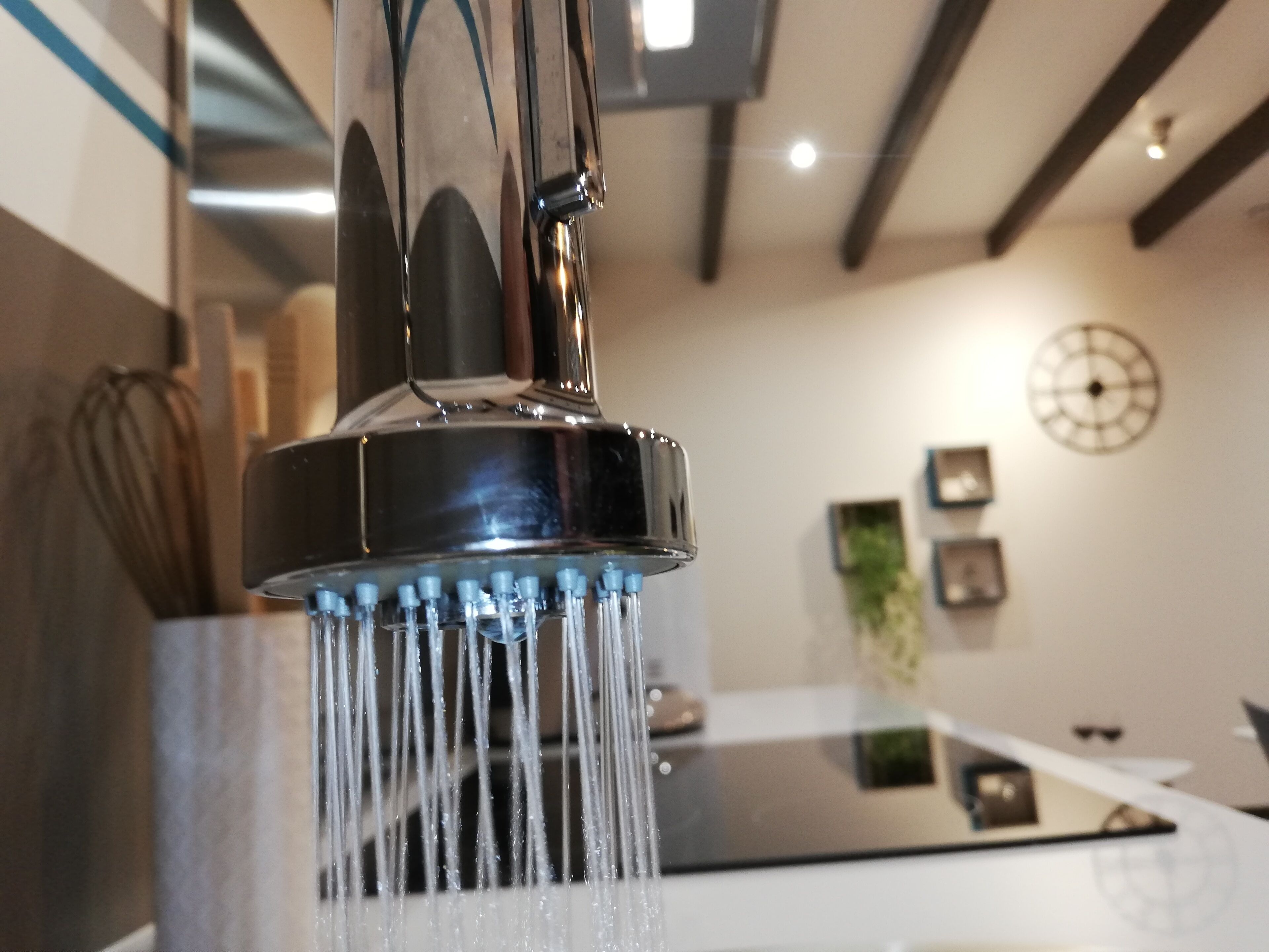 Eine moderne Küche mit Armatur aus Edelstahl und einer sichtbaren Spritzschutzwand.
