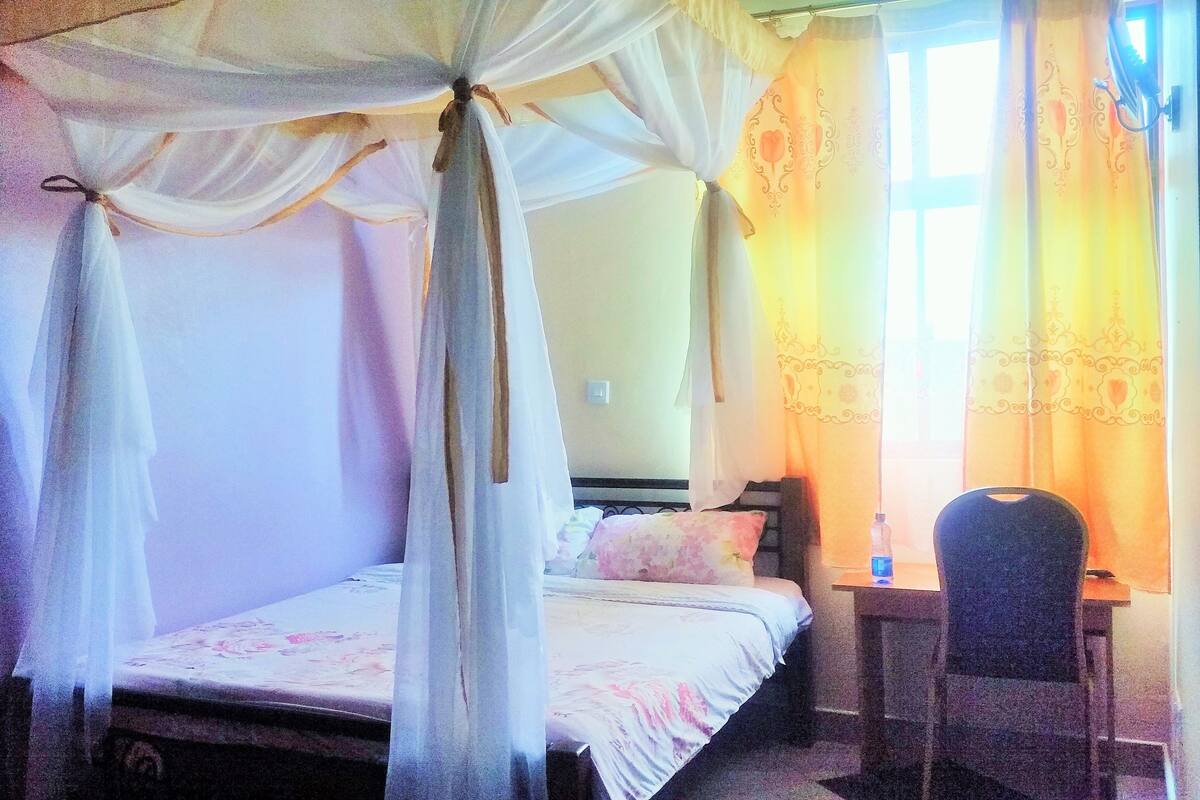 Una habitación con una cama, un escritorio y una silla.
