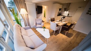 Una sala moderna con sofá, una mesa de centro y un comedor con sillas y una mesa.