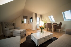 Ein modernes Wohnzimmer im Loft-Stil mit hohen Decken, einem Essbereich und einem großen Fenster für natürliches Licht.