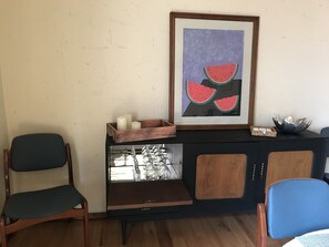 Comfortable seating area with a cabinet and artwork.