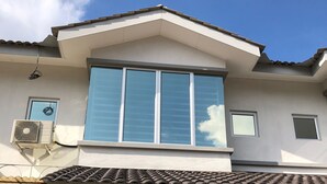 A two-story building with a large window, an air conditioning unit, and a tiled roof. - De Little Cabin near Sunway Lost World of Tambun Ipoh, Perak Malaysia. (Ipoh)
