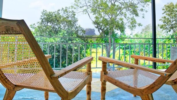 Two wicker chairs with woven seats and backs, positioned on a balcony with a metal railing. - Sigiriya Rock Hide (Sigiriya)