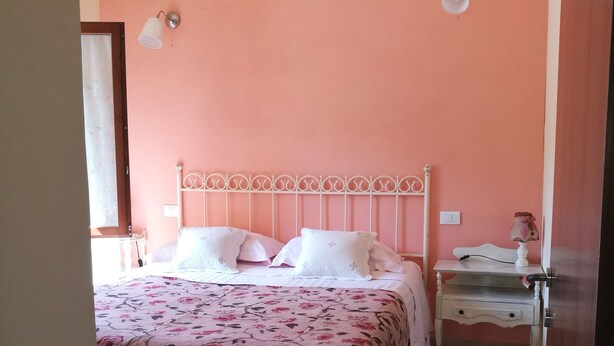A bedroom with a bed, bedside tables, and a door.