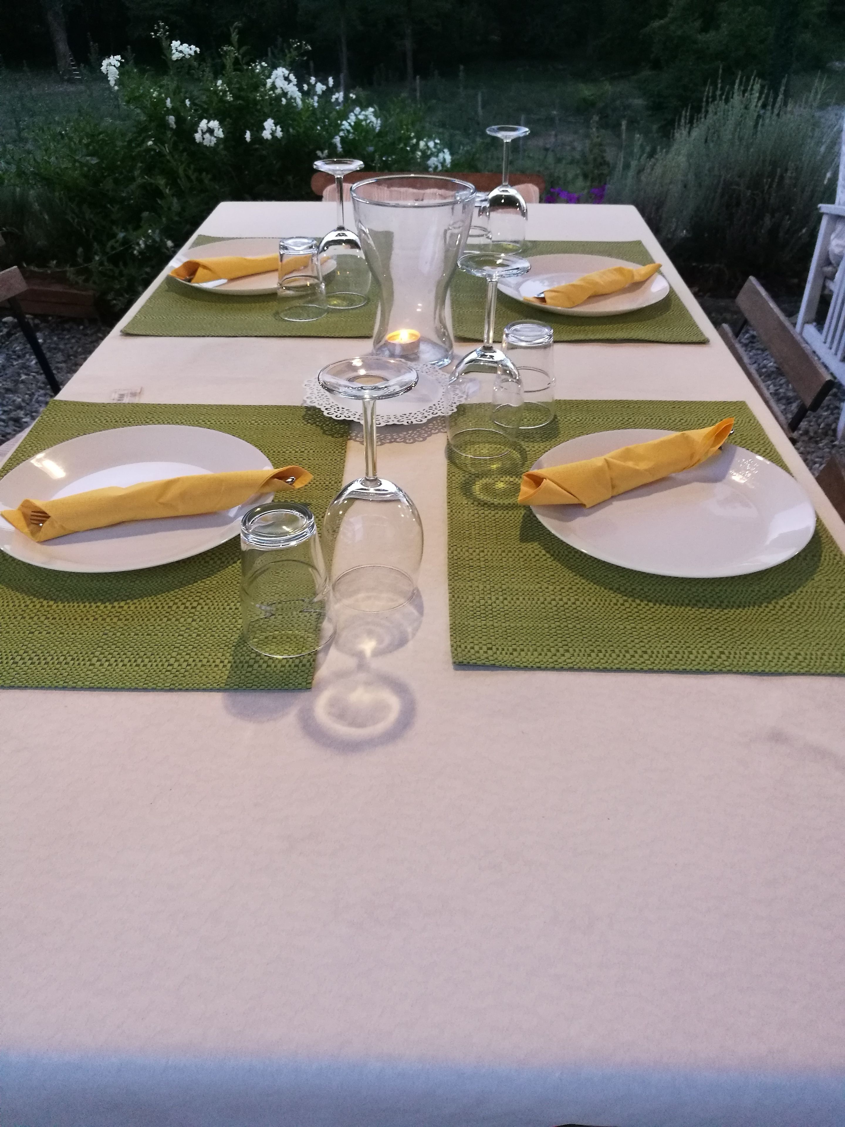 Een gedekte tafel met borden, servetten en wijnglazen.