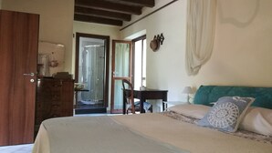 Un dormitorio con cama, cómoda de madera, escritorio y silla.