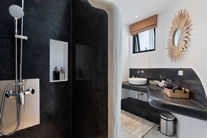 A modern bathroom with a black marble shower, a white sink, and a mirror with a sunburst frame. - villa PALAPA bophut koh samui (Bo Put)