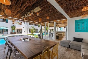 A spacious indoor area with a pool, a wooden dining table, and seating arrangements. - villa PALAPA bophut koh samui (Bo Put)
