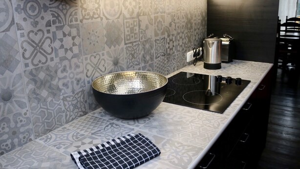 A modern kitchen with patterned tiles, a large black bowl, a gas stove, and a kettle. - a-domo Apartments Oberhausen - Studio Apartments & Flats - short or longterm - single or grouptravel (Oberhausen)